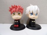 two figurines of anime characters sitting on a table