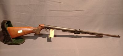 an old rifle with a wooden barrel on a stand