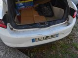 a white car with a trunk full of boxes in the back