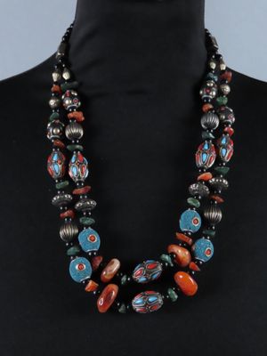 une femme portant un collier composé de perles multicolores, sur un mannequin