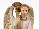 statue of an angel holding a torch in his right hand