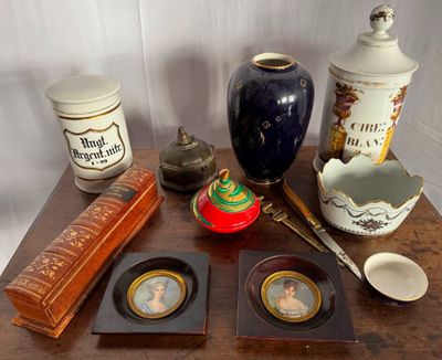 une table sur laquelle sont posés divers objets, notamment un vase, une théière et d'autres objets