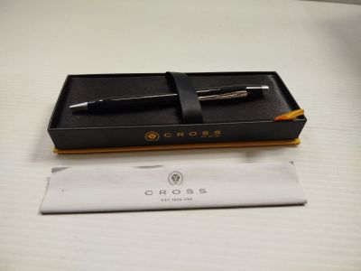un stylo et un crayon dans une boîte posée sur une table