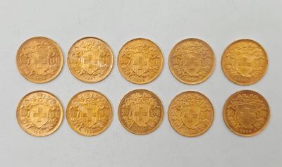 un gros plan sur plusieurs pièces d'or posées sur une surface blanche