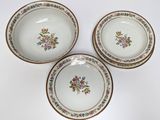 three plates with floral designs on them are sitting on a white surface