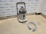 a vacuum that is sitting on the floor next to a hose