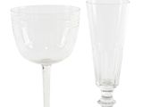 two clear wine glasses sitting next to each other on a white surface