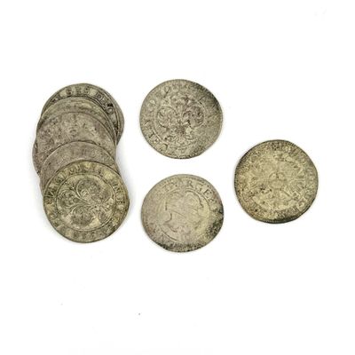 plusieurs pièces d'argent empilées les unes sur les autres sur une surface blanche