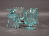 three glass vases sitting next to each other on a table