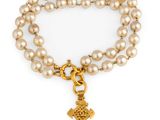 un bracelet en perles et en or orné d'une breloque en forme de croix