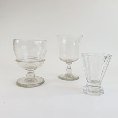 three glasses sitting next to each other on a white surface