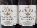three bottles of red wine are lined up on a table