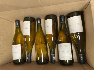 six bottles of white wine in a cardboard box on a table