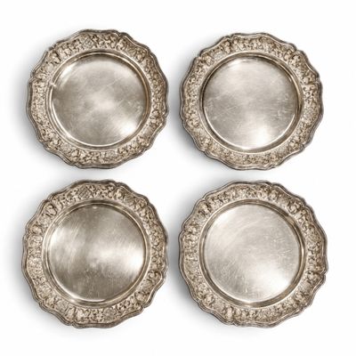 quatre assiettes plaquées argent sur fond blanc