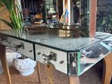 a glass table with a mirror on it in a living room