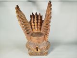 a wooden sculpture of a bird with wings on it