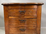 une vieille commode en bois surmontée de trois tiroirs