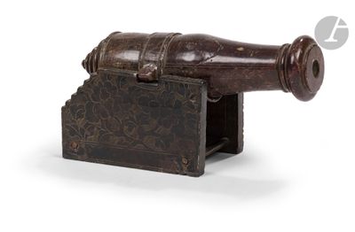 un vieux canon en bois posé sur un socle, sur fond blanc