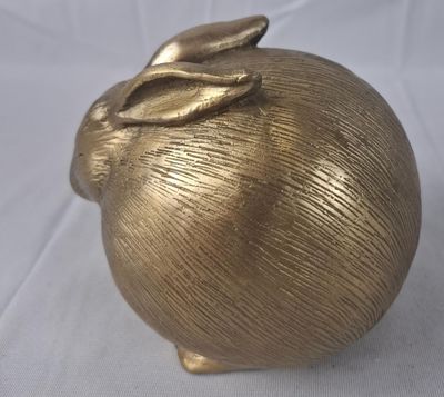 une pomme dorée surmontée d'une feuille