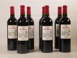 quatre bouteilles de vin rouge sont alignées sur une table