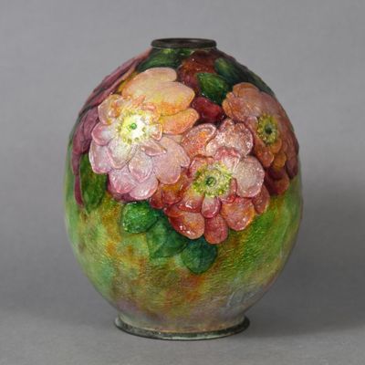 a vase with flowers painted on it sitting on a table