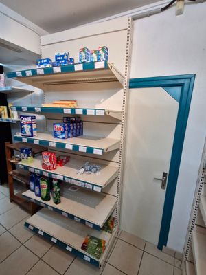 many shelves in the corner of a store that have various items on them