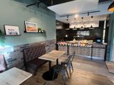 tables and chairs in a restaurant with a bar in the background