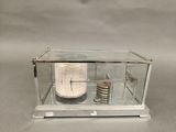 une horloge placée dans une vitrine posée sur une table