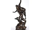 une statue en bronze représentant un homme aux prises avec une femme, posée sur un socle en marbre