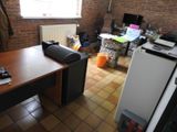 a desk with a computer on it in a room with a brick wall