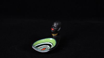 une petite figurine représentant un chat noir aux yeux verts et rouges