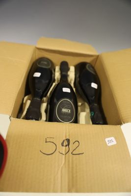 cinq bouteilles de vin dans un carton posé sur la table