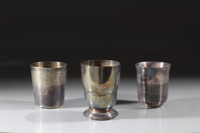 trois coupes en argent posées sur une table, sur fond noir