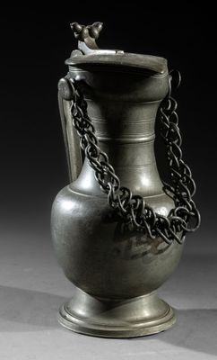 a silver vase with a chain around it on a table