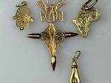 four charms on a white surface one is gold and the other is silver
