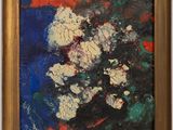 une peinture abstraite représentant des fleurs, dans un cadre doré, accrochée sur un mur blanc