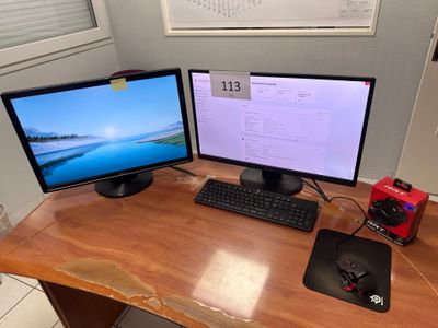 deux écrans d'ordinateur posés sur un bureau, avec une souris et un clavier