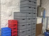 many plastic boxes stacked up in a room