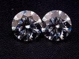 une paire de diamants taille ronde sur un fond noir