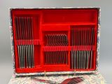 une boîte rouge contenant tout un tas de fourchettes et de couteaux