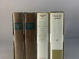 three books are stacked on top of each other on a white surface