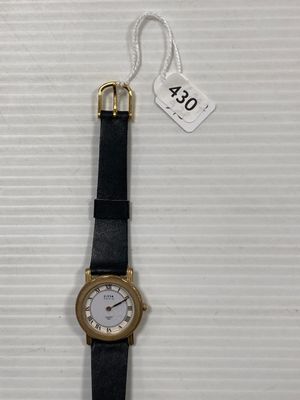 gros plan d'une montre sur une surface blanche avec une étiquette de prix