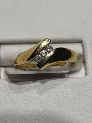 bague en or et diamants dans un coffret blanc posé sur une surface blanche