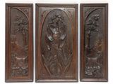 three wooden panels with carvings of animals and flowers on them