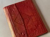 un vieux livre rouge à la couverture en cuir posé sur une table