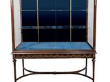 an antique display case with glass doors and a blue velvet cushion