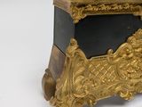 a gold clock sitting on top of a black table