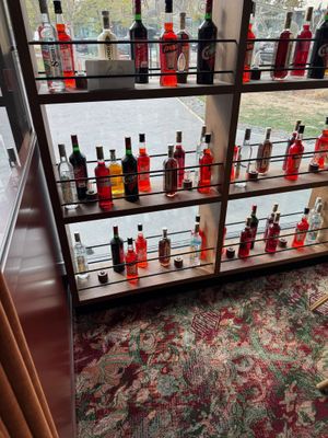 Des bouteilles d'alcool sont alignées sur une étagère dans une pièce