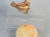 a small bird sitting on top of a clear box next to a rock