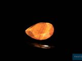 un gros plan d'une pierre jaune sur une surface noire
